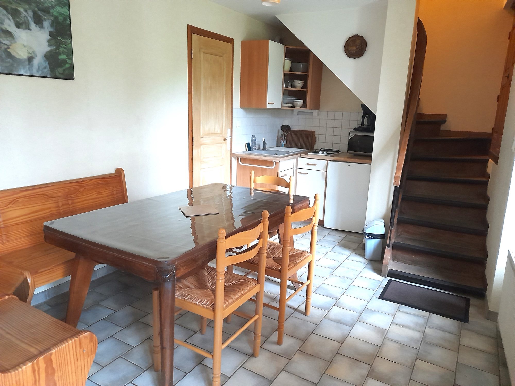 Cuisine et salle à manger du gîte, avec table en bois et escalier